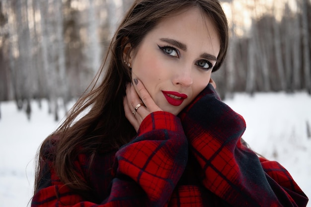 Woman with red lips in winter forest