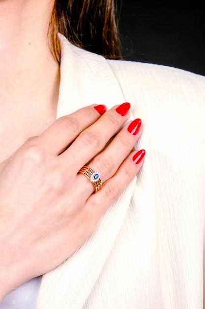 a woman with red nail polish is holding a ring with a star on it