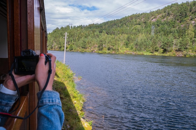 Foto una donna con lo smalto rosso che fotografia il lago