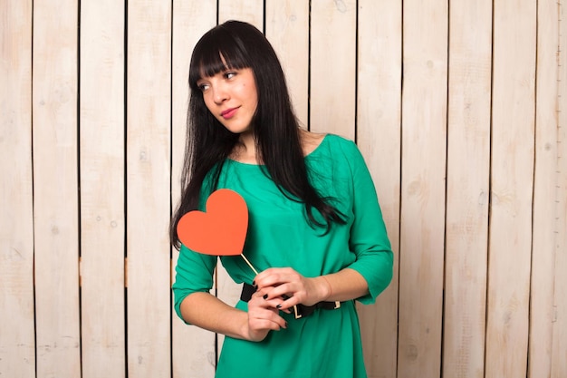 Woman with red shape of heart in green dress in Valentine's day