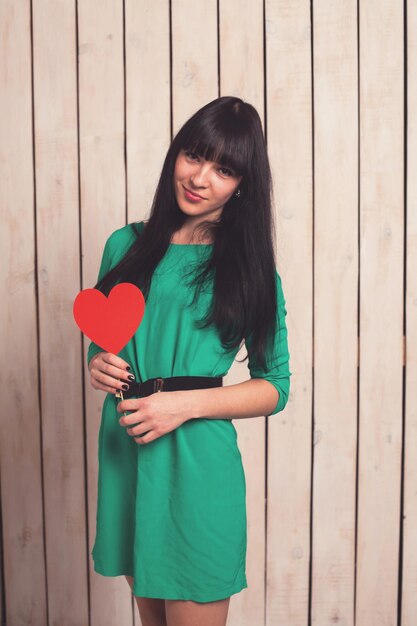 Woman with red shape of heart in green dress in Valentine's day