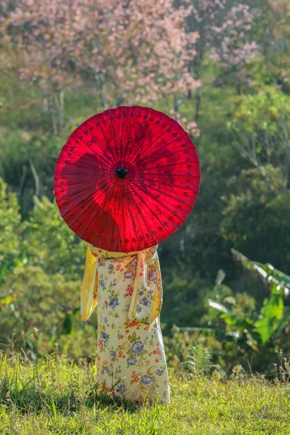 Photo woman with red umbrella standing on field