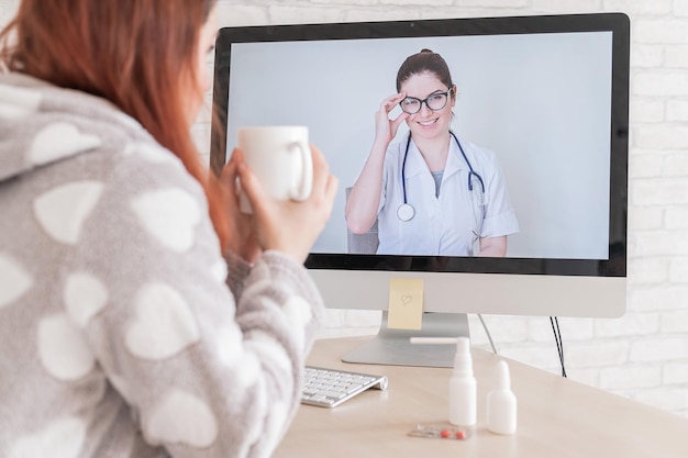 A woman with a respiratory illness is quarantined and is talking to a GP on a webcam A doctor for an online consultation for a sick patient