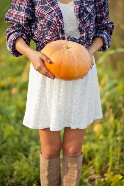 Woman with a ripe pumpkin in a garden