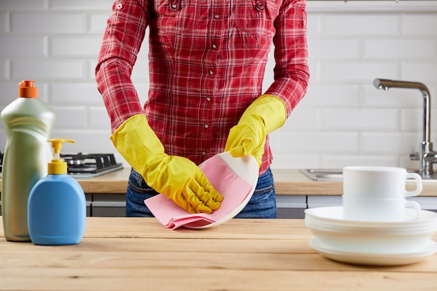 Photo woman with rubber gloves cleaning in the kitchen