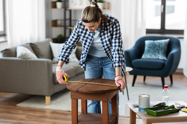 woman with ruler measuring table for renovation