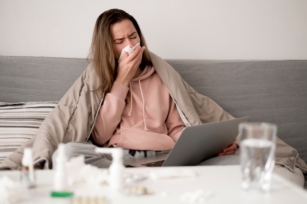 Photo woman with runny nose staying under blankets
