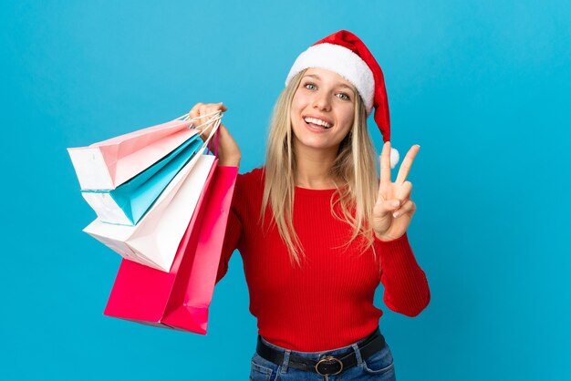 woman with santa hat holding shopping bags