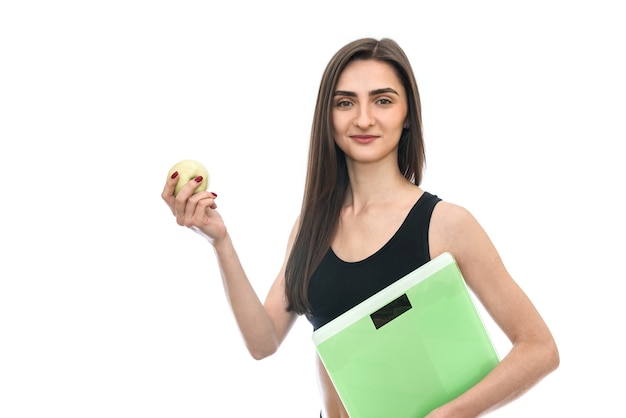 Woman with scale and apple isolated on white