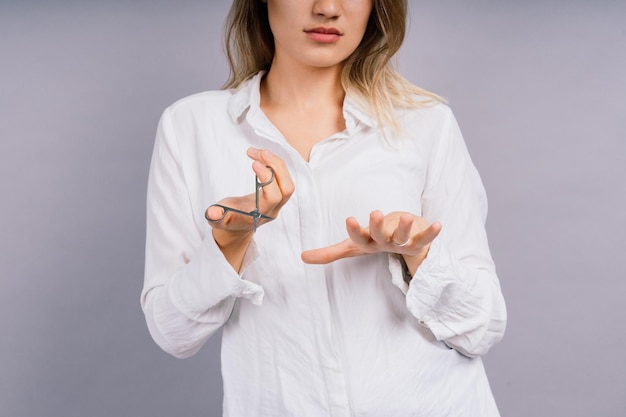 Woman with scissors having hair cut Amazed female with straight hair scissor Haircare concept