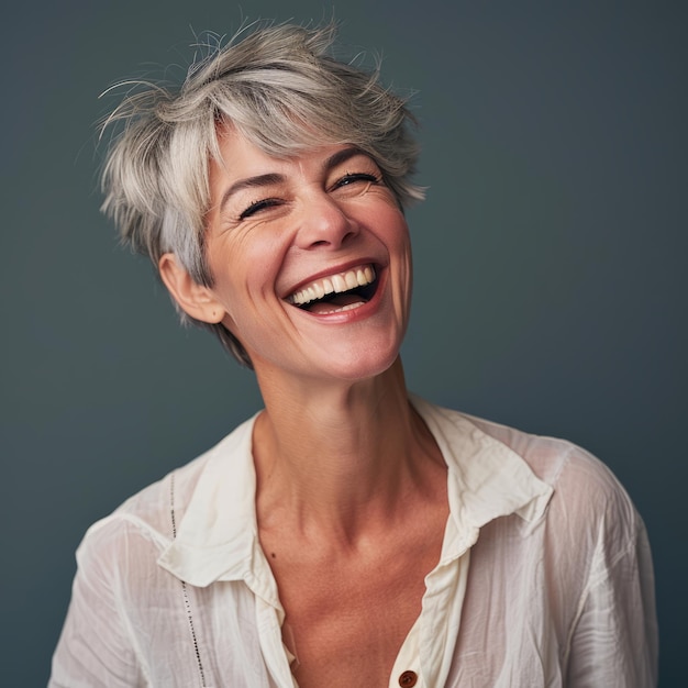 A woman with short gray hair is laughing