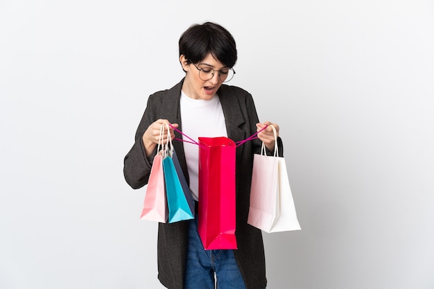 Woman with short hair over holding shopping bags and looking inside it