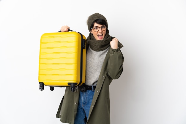 Woman with short hair over isolated background in vacation with travel suitcase