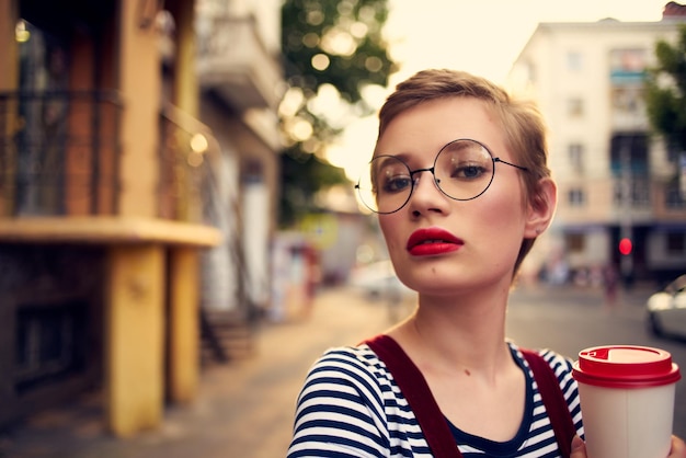 Photo woman with short hair outdoors cup of drink lifestyle