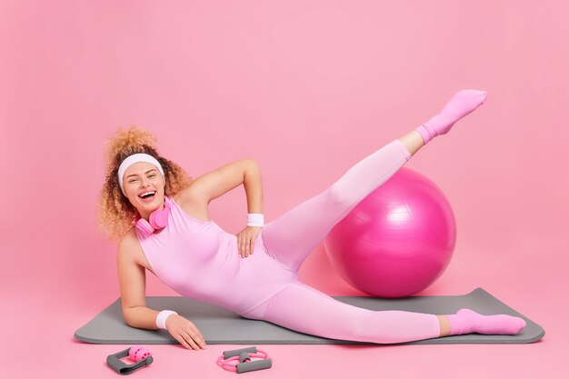женщина со стройной фигурой упражнения на фитнес-коврике поднимает ноги ведет позы активного образа жизни