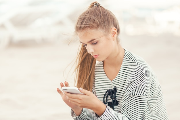 Woman with a smartphone on the beach vacation and technology