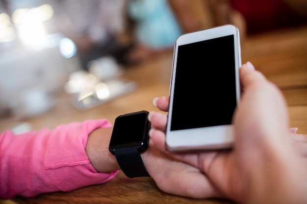 Woman with smartphone and smart watch