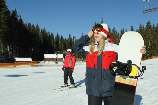 Woman with snowboard in sunny day space for text