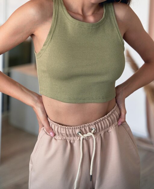 Woman with straight hair wears green cropped shirt indoors