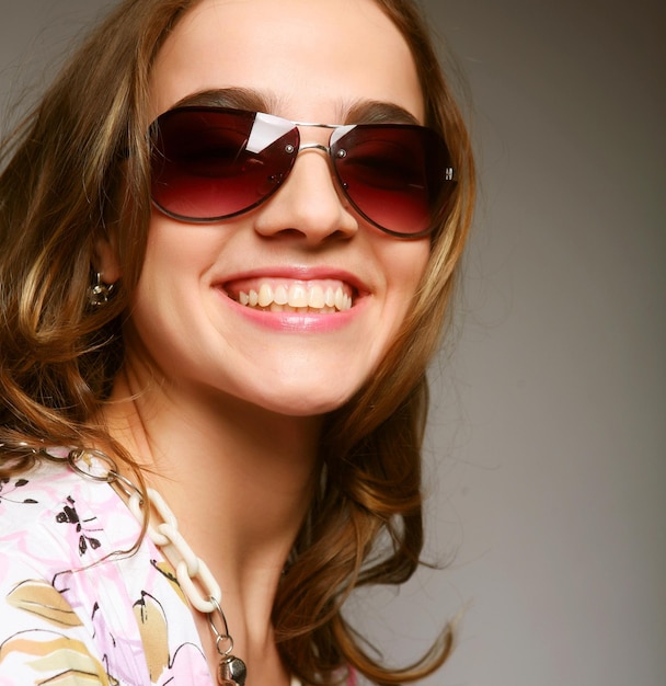 Woman with sunglasses over grey background