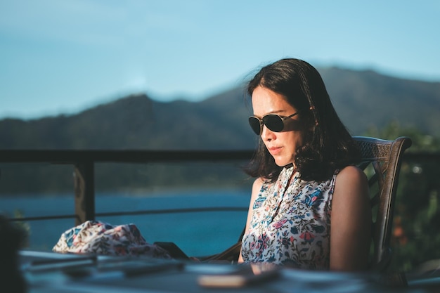 Woman with sunglasses using cell phone outdoor