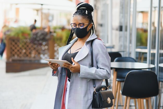 Woman with surgical mask using a tablet