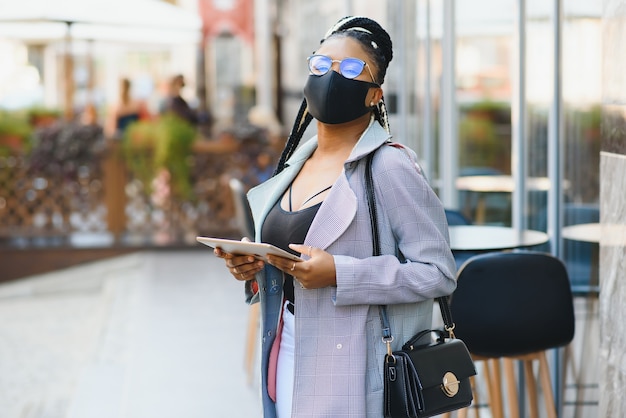 Woman with surgical mask using a tablet