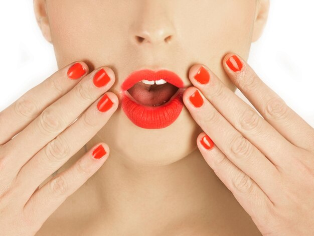 A woman with surprised gesture with red lips and nails in a close up view