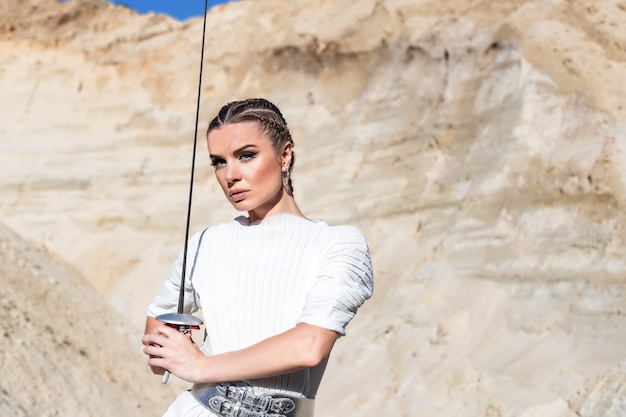 woman with sword in total white outfit in desert