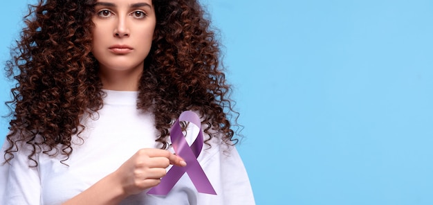 Woman with symbol of breast cancer awareness. Female holds pink ribbon. Isolated blue background