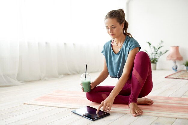 woman with tablet pc and drink at yoga studio