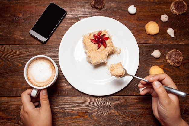 Woman with tasty dessert and cup coffee in cafe