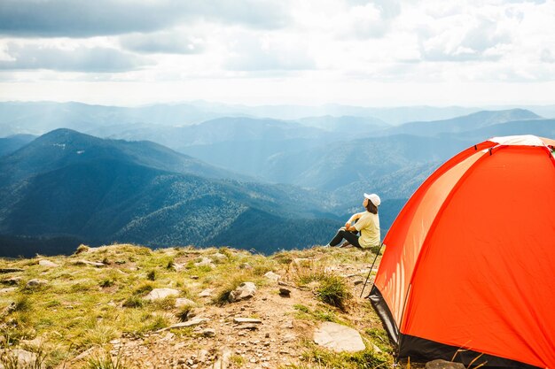 Woman with a tent on top of a mountain