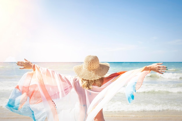 写真 晴れた日,晴れた空の前でビーチに立っている時,維の帽子をかぶった女性