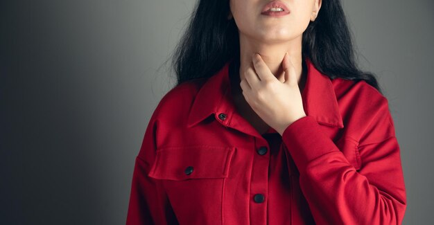 Photo woman with throat sore is holding her aching throat body pain concept