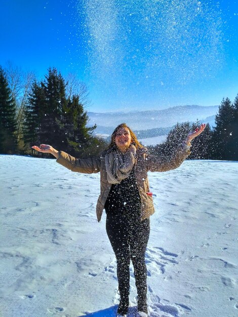 Foto donna che lancia neve all'aperto