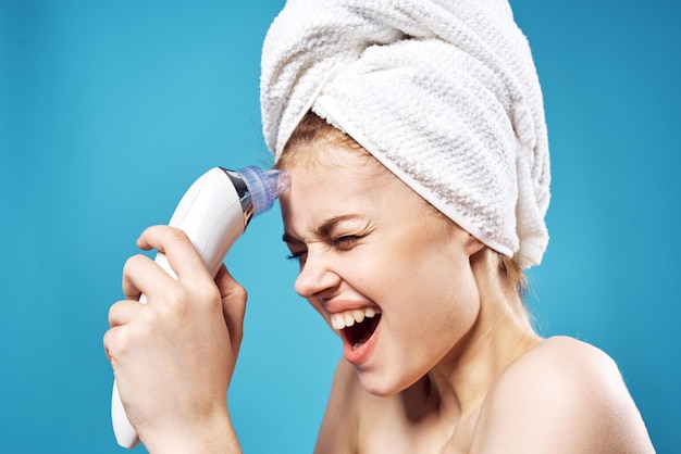 Photo woman with towel on head cleaning face skin care blue background