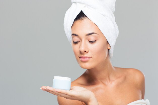 Woman with towel on head holding cream jar