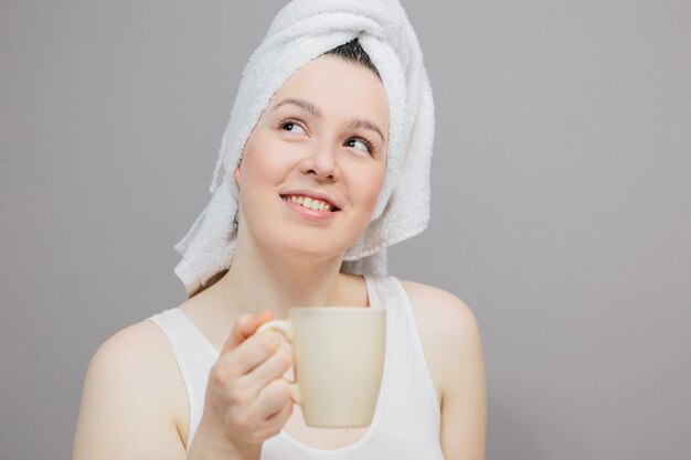 woman with a towel on her head and a cup