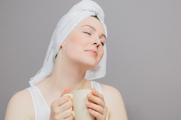 woman with a towel on her head and a cup