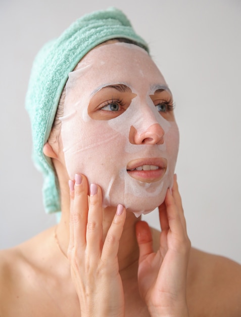 a woman with a towel on her head and a mask on her face