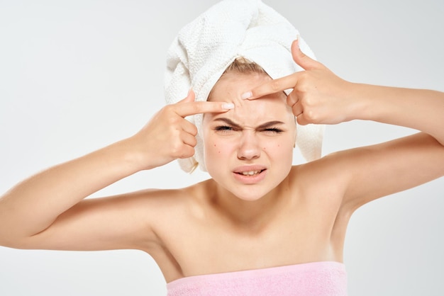 woman with a towel on her head squeezes out pimples on her face clean skin health High quality photo