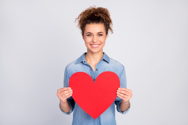 woman with trendy hairstyle holding big heart