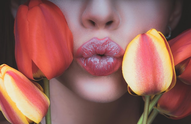 Женщина с тюльпанами целует чувственные губы, целуя женский день марта