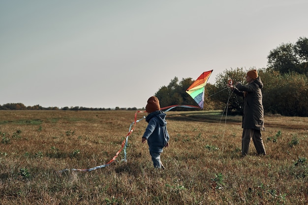 Una donna con un bambino di due anni sta facendo volare un aquilone. giochi con bambini, maternità.