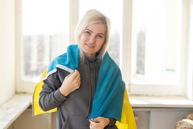 ウクライナの旗を持つ女性。ロシアとウクライナの間の戦争を止めなさい。ウクライナにとどまりなさい。平和と世界を祈り、希望します。コピースペース