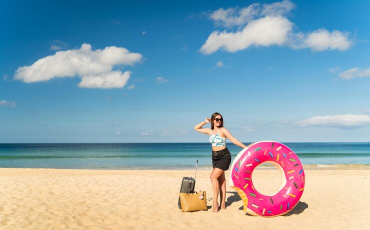 Photo 空に向かってビーチで傘をかぶった女性