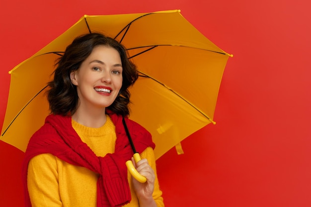 Woman with umbrella on color background