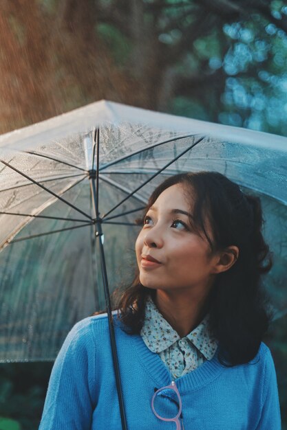 雨の日に傘を持つ女性。