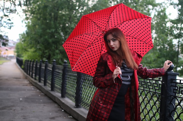 Woman with umbrella red on street tree